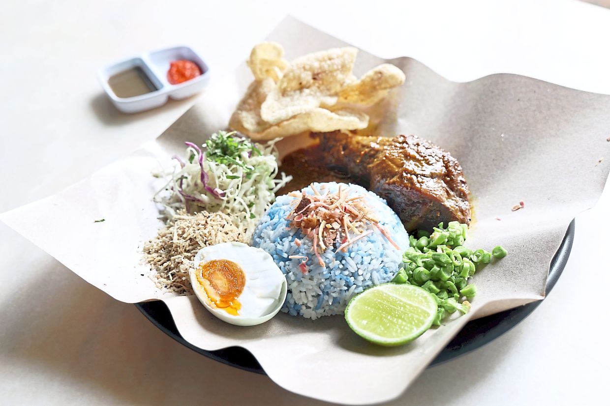 Nasi kerabu’s defining feature is the brilliant blue rice that is naturally coloured with blue pea flower (bunga telang). — Filepic