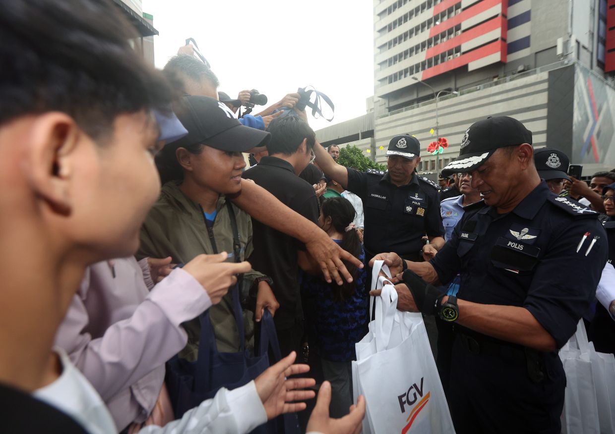 Led by Comm Muhammed Hasbullah (right), 2,000 packs of bubur lambuk were distributed to traffic police and the public at Jalan Tunku Abdul Rahman.
