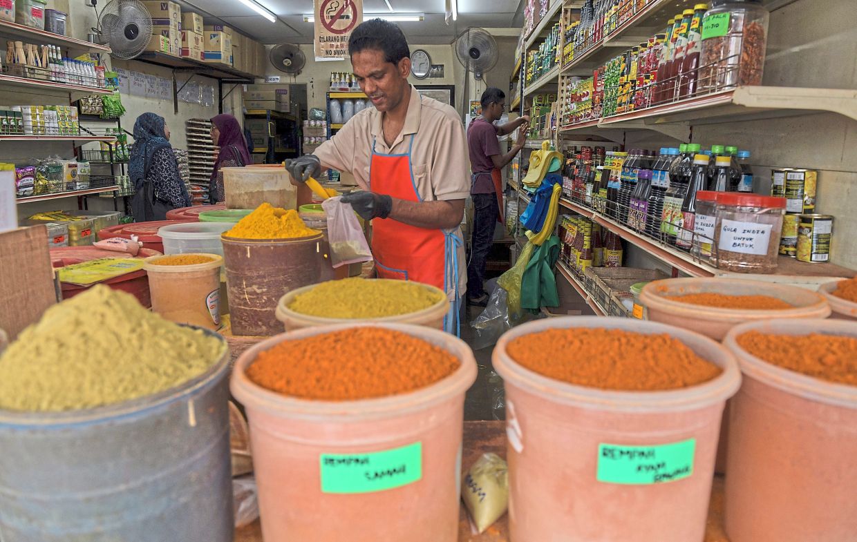 Shahul Hameed deftly mixes spices in a plastic bag for customers, depending on what they are cooking. — Photos: Bernama