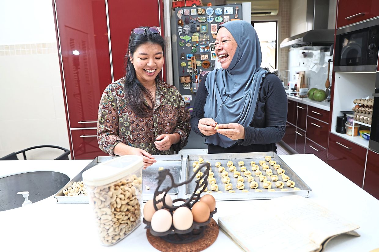 It is a bonding session between Tanti Didi (right) and daughter Ina Enisa when baking Didi's mum's heirloom cashew nut biscuit for Hari Raya at their home in Shah Alam. - AZMAN GHANI/The Star
