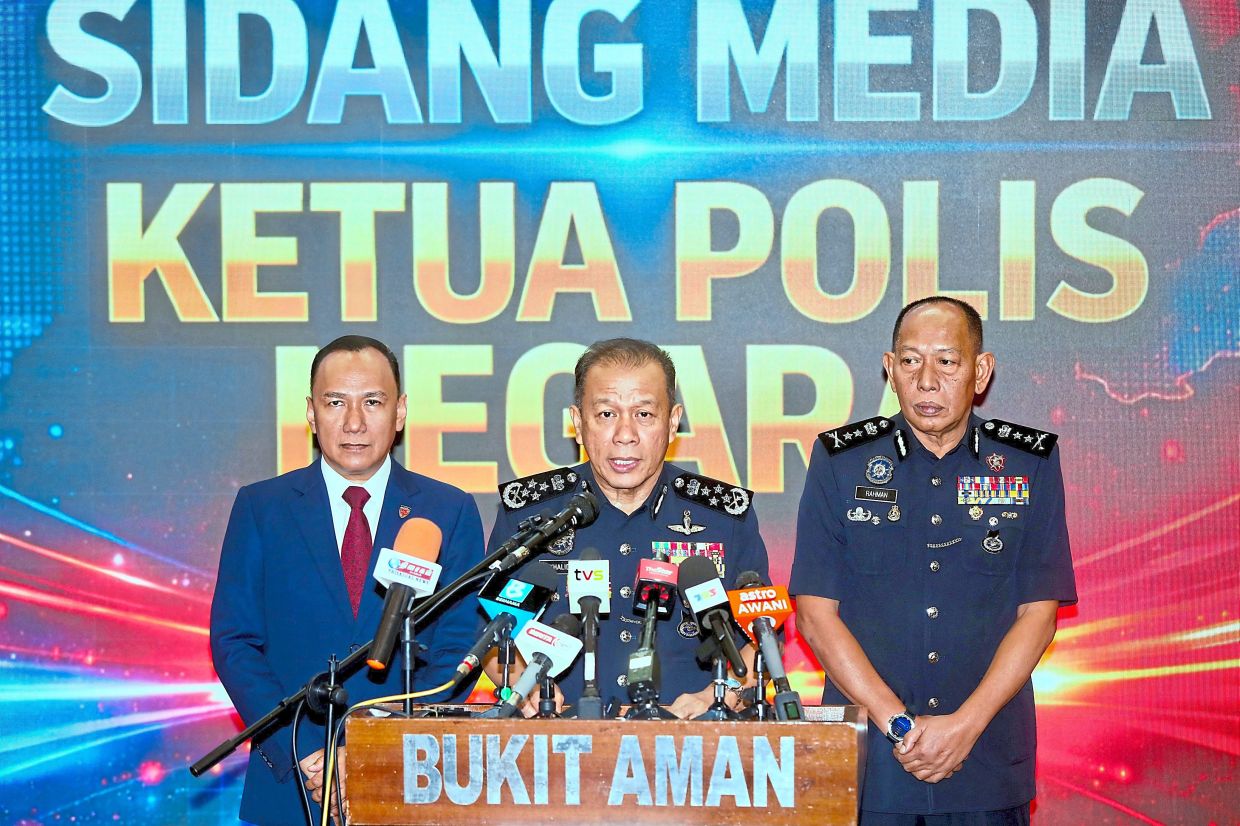 Calm in crisis: Mohd Khalid (centre) answering the media during the press conference at Bukit Aman. — LEONG WAI YEE/The Star