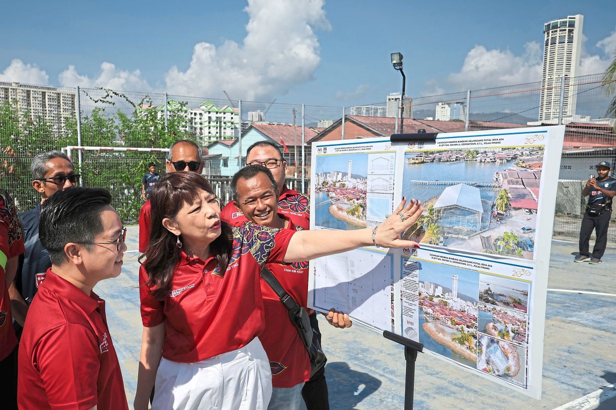 Lim (centre) and Wong (front left) looking at artist’s impressions of the upgraded facility.