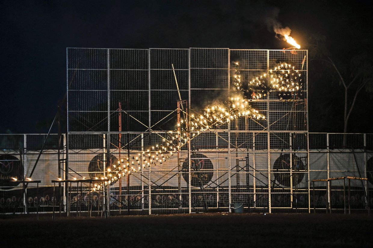 Lit oil lamps forming the shape of a keris at the festival.