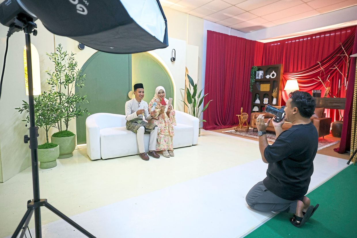 Muhammad Shahrul (right) taking photos of husband-and-wife Mohd Syafiq and Puteri Nursyafiqah at his studio in Kuantan.