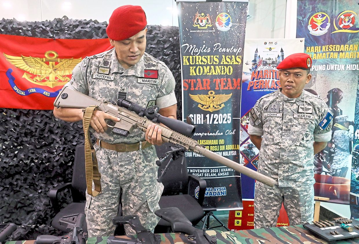 Weapons training: Kapt Syuzefril inspecting a gun during a STAR Team event in Port Klang. — Bernama