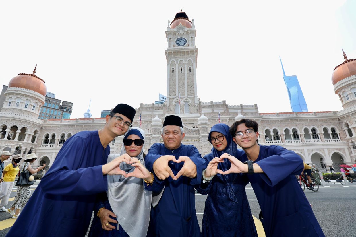 Muhammad Faiz Ahmad (centre) and his family share a light-hearted moment as they pose for a photo at the iconic Sultan Abdul Samad Building, savouring precious time together on the first day of Hari Raya.