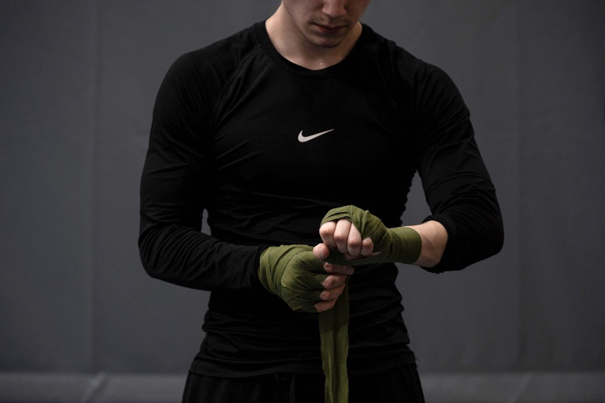 Kian, 19, young Greenlandic boxer, wraps his hands with gauze bandages before a training session at the Nuuk stadium, in Greenland, on March 4, 2026.