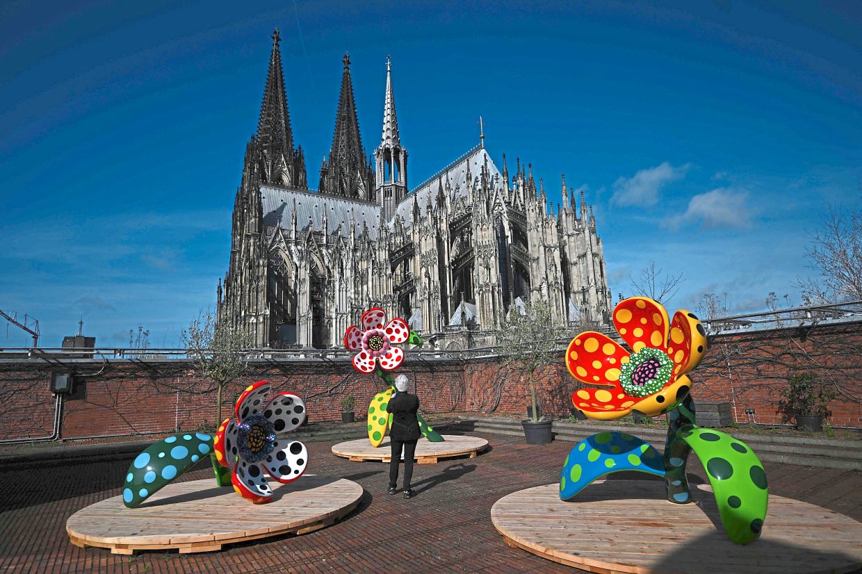 A view of Yayoi’s installation 'Flowers That Speak All About My Heart Given To The Sky', with Cologne Cathedral in the background. Photo: AP 