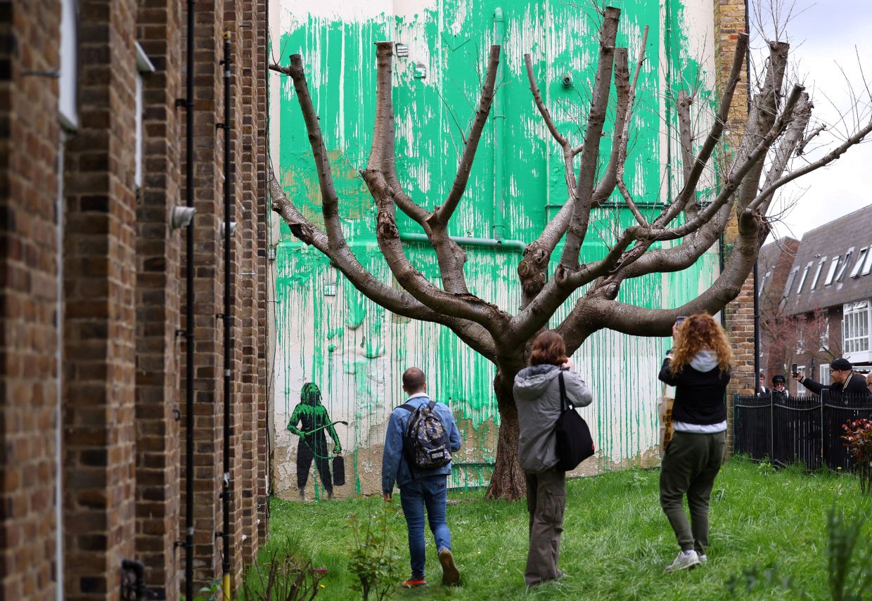 People view a new mural attributed to the British artist Banksy on a wall in north London in March 2024. Photo: Reuters 