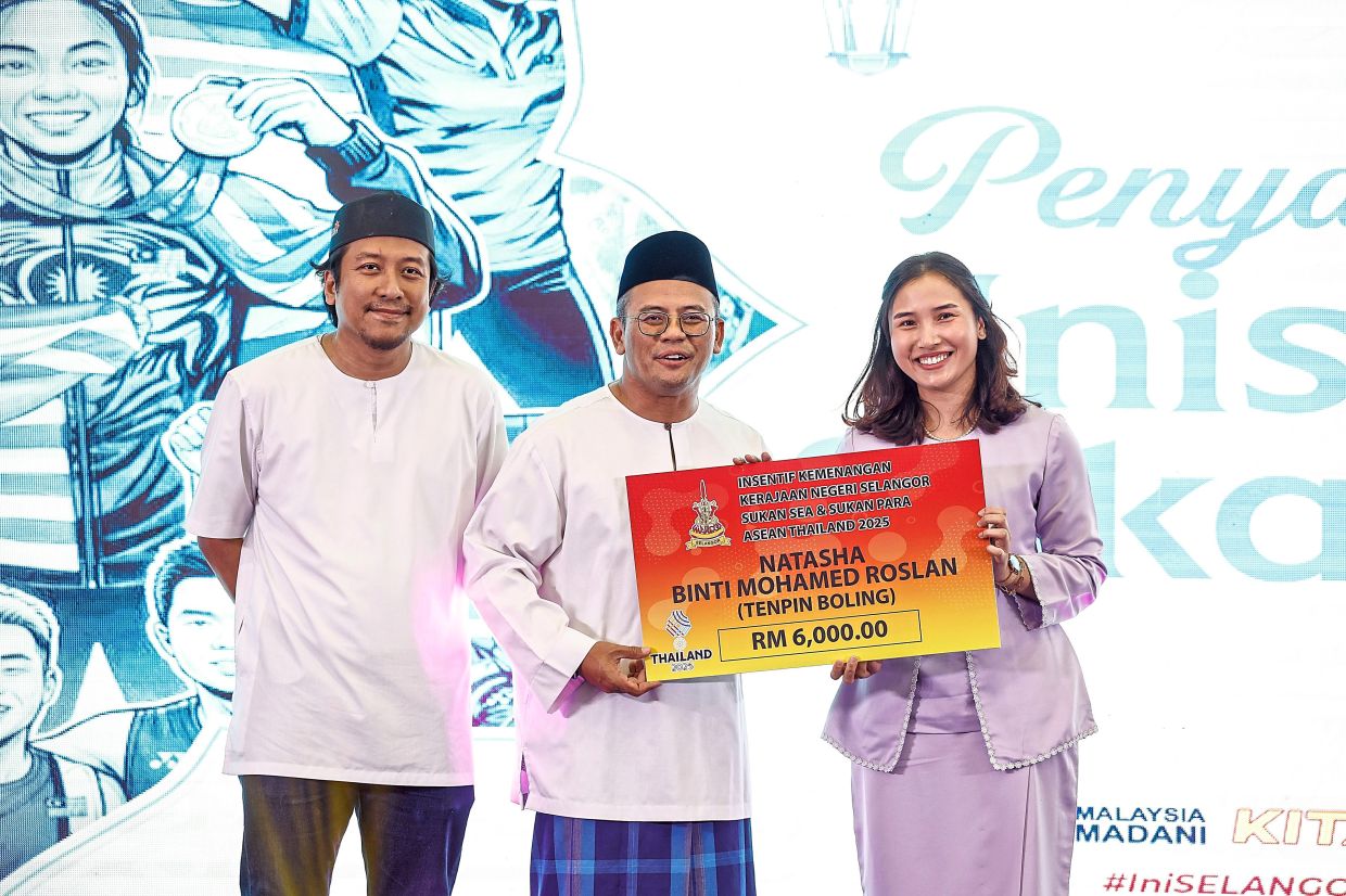 Amirudin presenting the SEA Games incentive to tenpin bowling athlete Natasha Mohamed Roslan. 