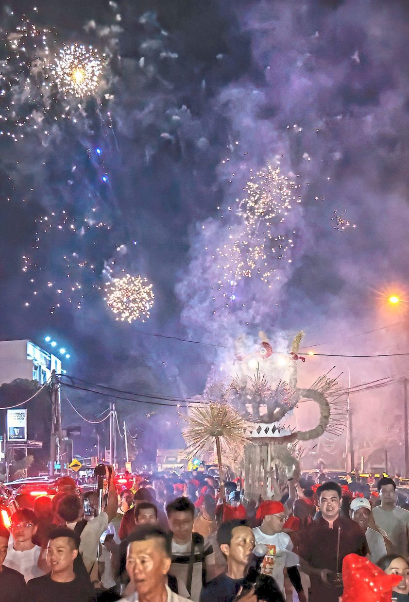 A fireworks display above the fire dragon procession as it moves through Pandamaran New Village in Klang for Heguang Festival. — Photos: ART CHEN/The Star