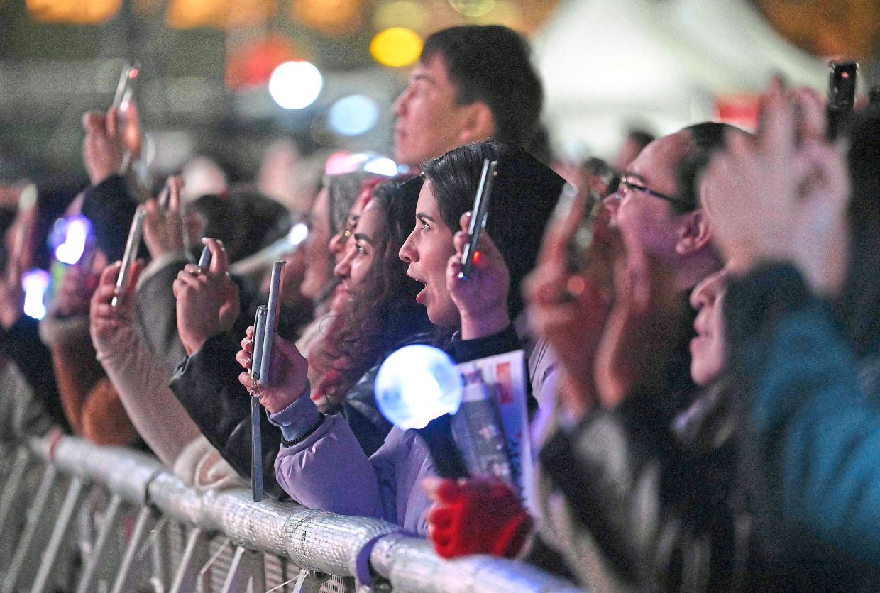 3. Fans reacting as they watch BTS’s comeback concert on a big screen set up outside the historic Gyeongbokgung Palace in Seoul. — AFP