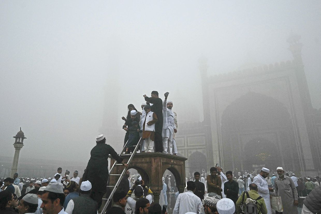 9. Muslim devotees celebrating after offering prayers at Jama Masjid in the old quarters of New Delhi, India. — AFP
