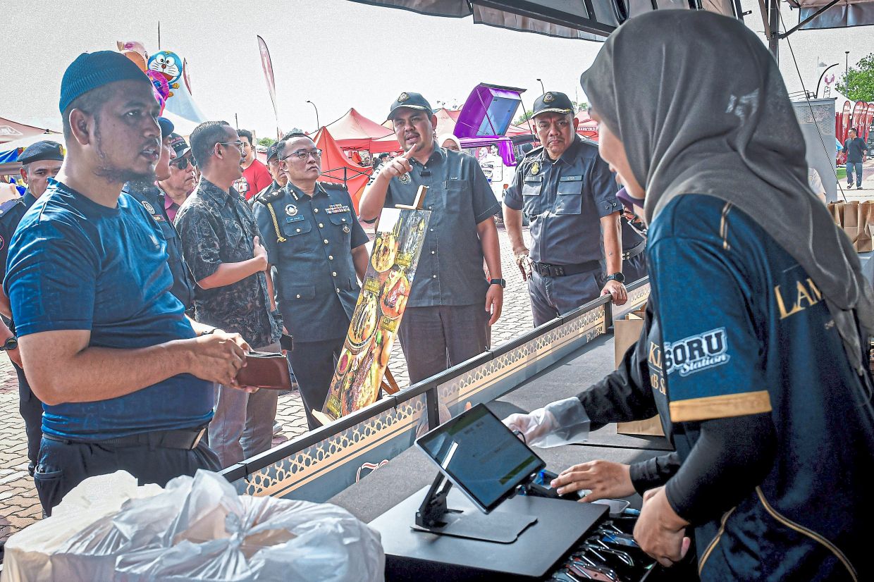 Muhamad Hanif (third from right) during an inspection of traders at the Shah Alam bazaar. 