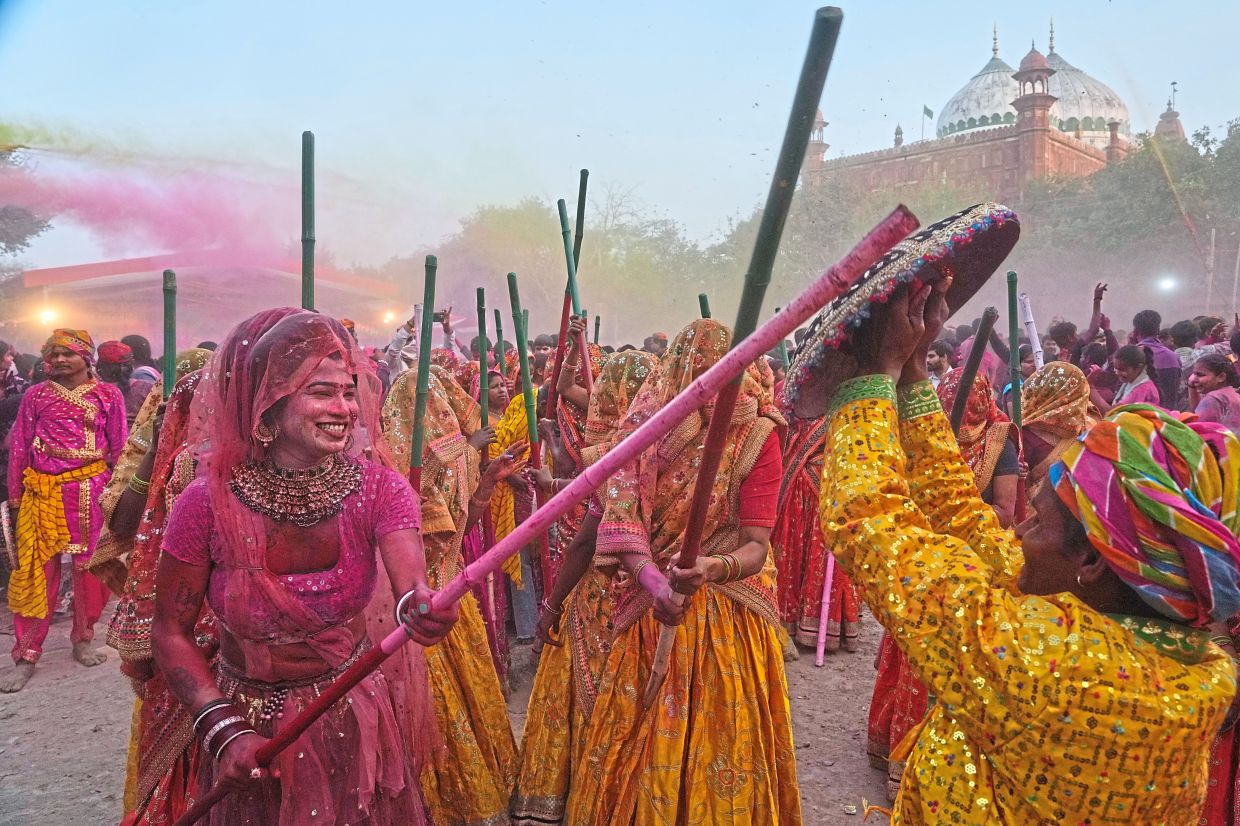 5. Women playfully strike men with wooden sticks in a re-enactment of Radha and Krishna’s legend during Lathmar Holi at the Shri Krishna Janmabhoomi Temple complex in Mathura, India. — AP