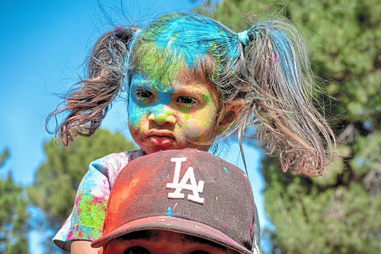 7. A girl riding on her father’s shoulders during Holi celebrations in Los Angeles in the United States. — AP