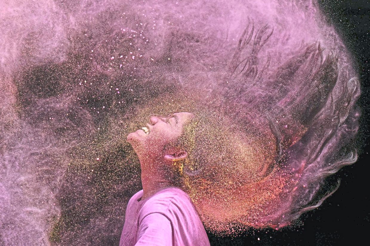 4. A girl flips her hair to disperse coloured powder during Holi celebrations in Chennai, India. — AFP