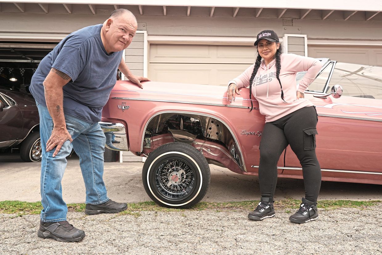 Alvarado, left, and customer Sandy Avila, pose with her 1966 Chevy Impala, at his in Monrovia, Calif., Tuesday, March 10, 2026. (AP Photo/Damian Dovarganes)