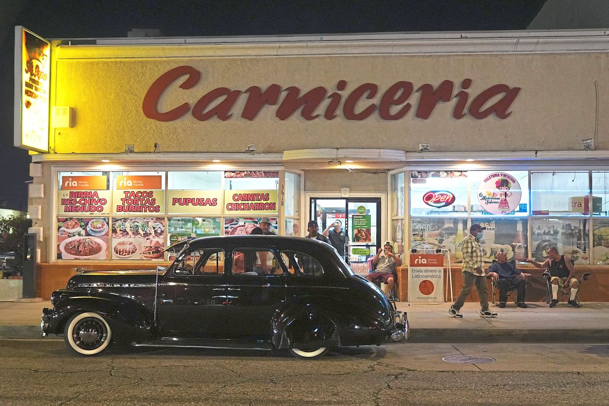 A vintage lowrider is parked in front of a butcher's shop at the recent 6th Annual Lady Lowrider Cruise Night in Pasadena, California.