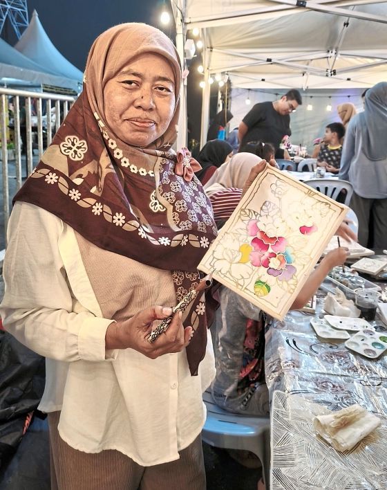 Batik instructor Sarimah says it is nice to meet new people and share traditional crafts with the younger generation.