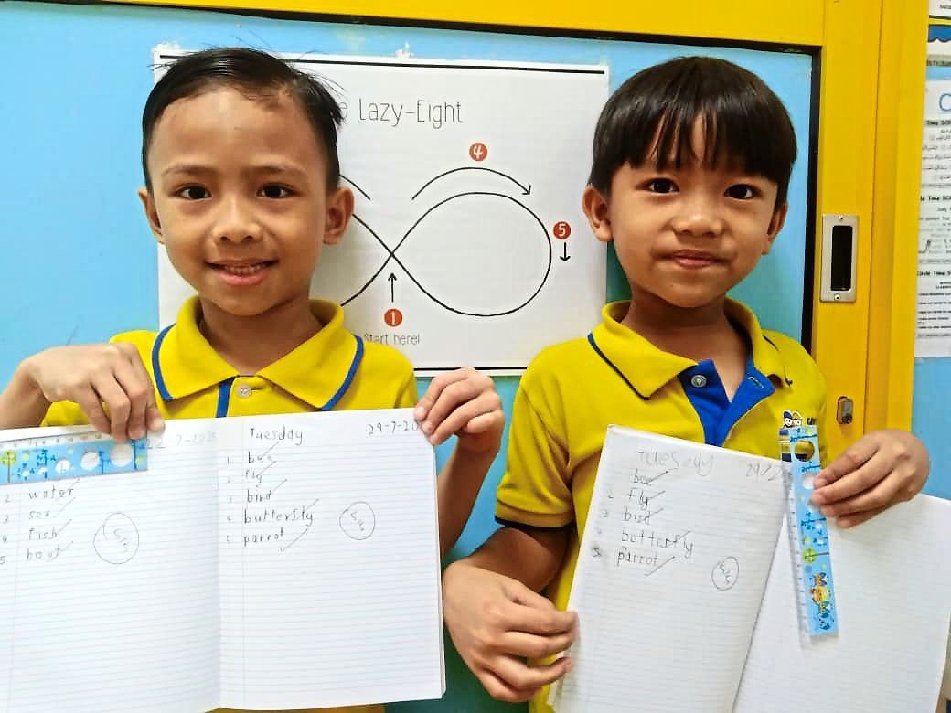 The cheerful smiles of kindergarten pupils after scoring full marks in the weekly kindergarten spelling session.