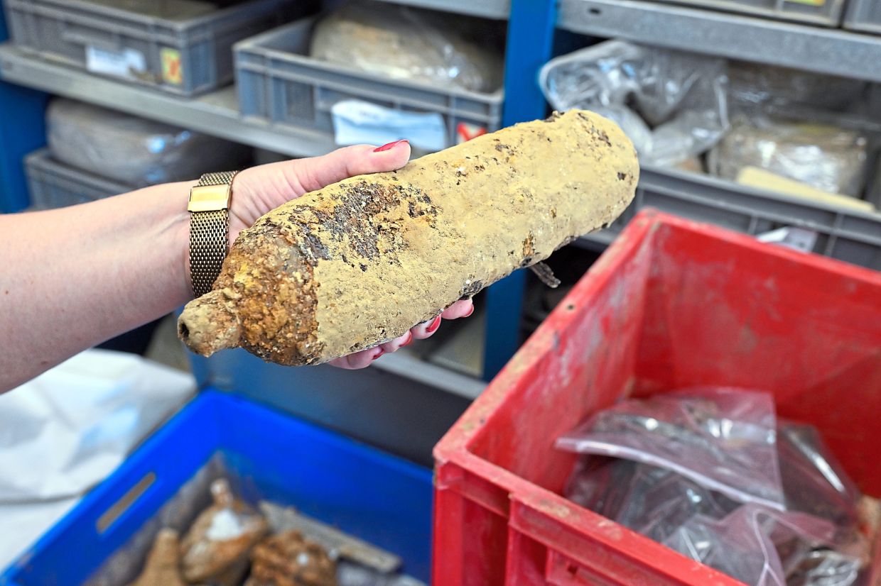 Kaszab-Olschewski holding parts of a British bomber in her hands.