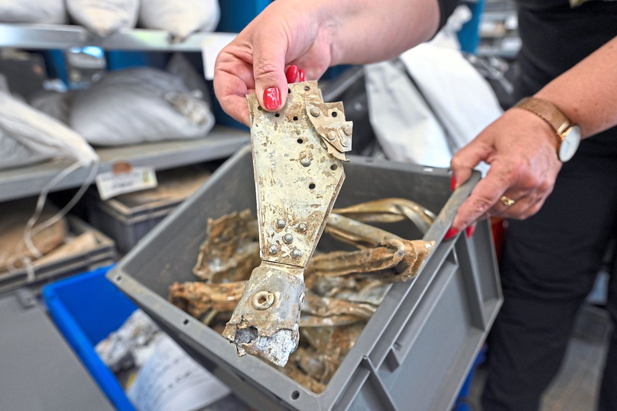 Kaszab-Olschewski holding parts of a British bomber in her hands.