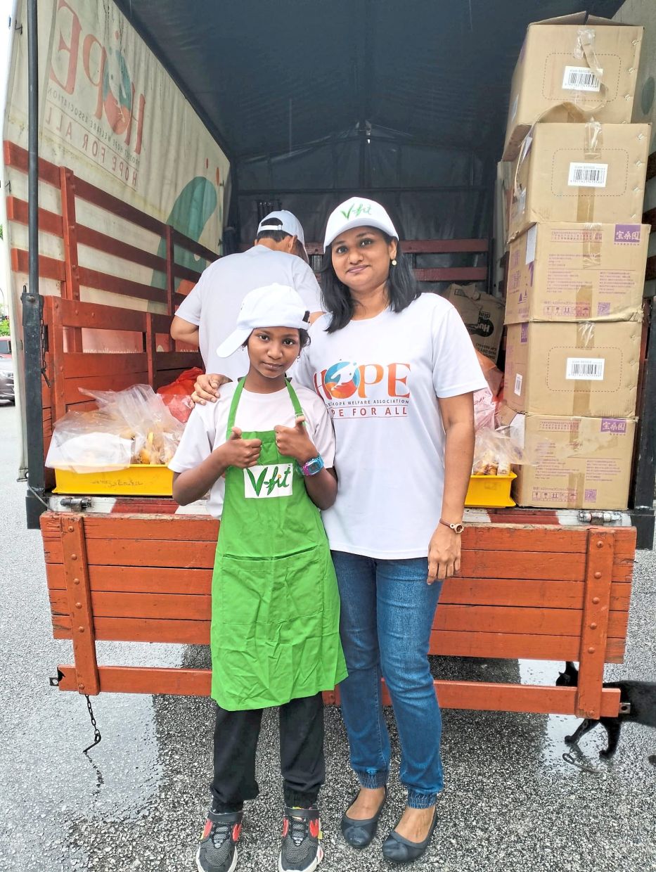 Debra Sarah (right) and her daughter Krisandrah getting ready to distribute food packages to those in need. Photo: Project Hope Welfare Association