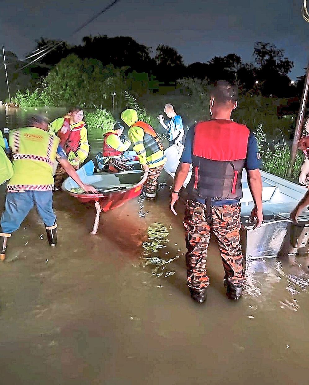 Fire and Rescue Department personnel setting up boats to rescue affected residents during the flood at Jalan Gurney.
