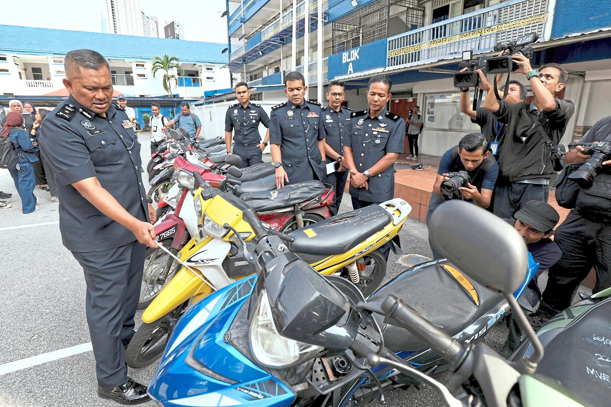 Not so fast: SAC Mohammad Lazim (left) showing the stolen motorbikes seized during the operation in Wangsa Maju, at the district police headquarters. — LEONG WAI YEE/The Star