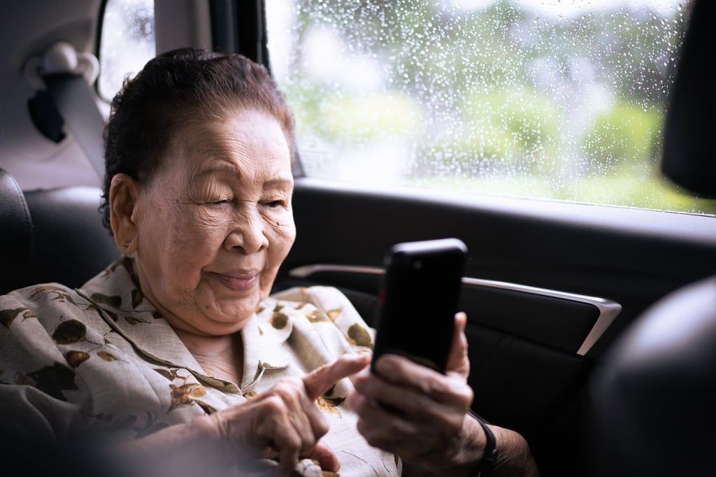 An elderly woman takes her time typing a message into her mobile phone. - Photo: Shutterstock