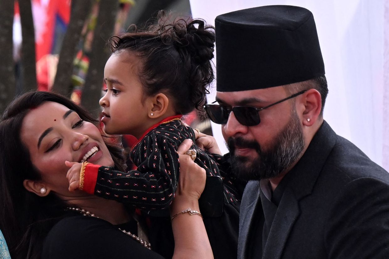 Nepal's newly sworn-in prime minister Balendra Shah with his wife Sabina Kafle and daughter Niloufer Shah attend a swearing-in ceremony in Kathmandu on Friday, March 27, 2026. Nepal's rapper-turned-politician Balendra Shah was sworn in as prime minister on March 27 after sweeping the first election since deadly anti-corruption protests toppled the government last year. -- Photo by PRAKASH MATHEMA / AFP
