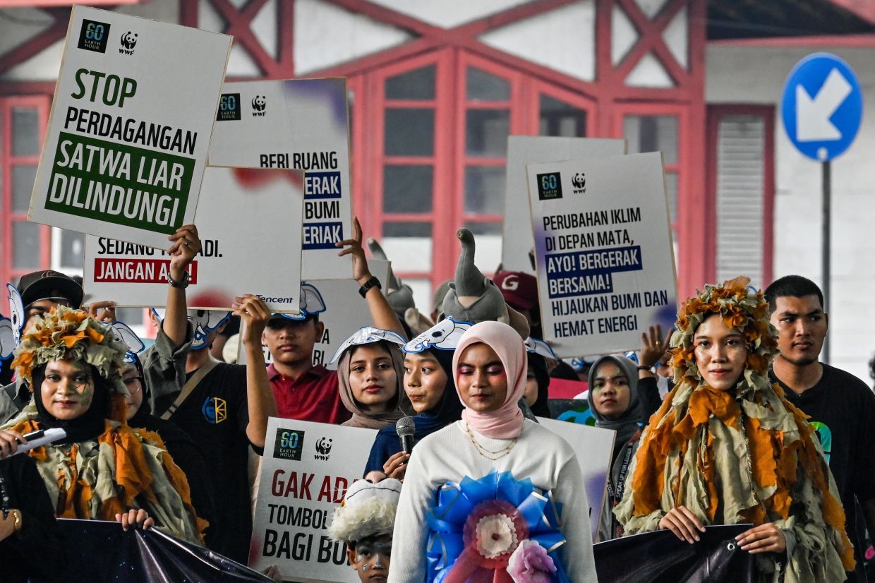 Environmental activists take part in a procession ahead of Earth Hour in Banda Aceh on Saturday, March 28, 2026. -- Photo by CHAIDEER MAHYUDDIN / AFP