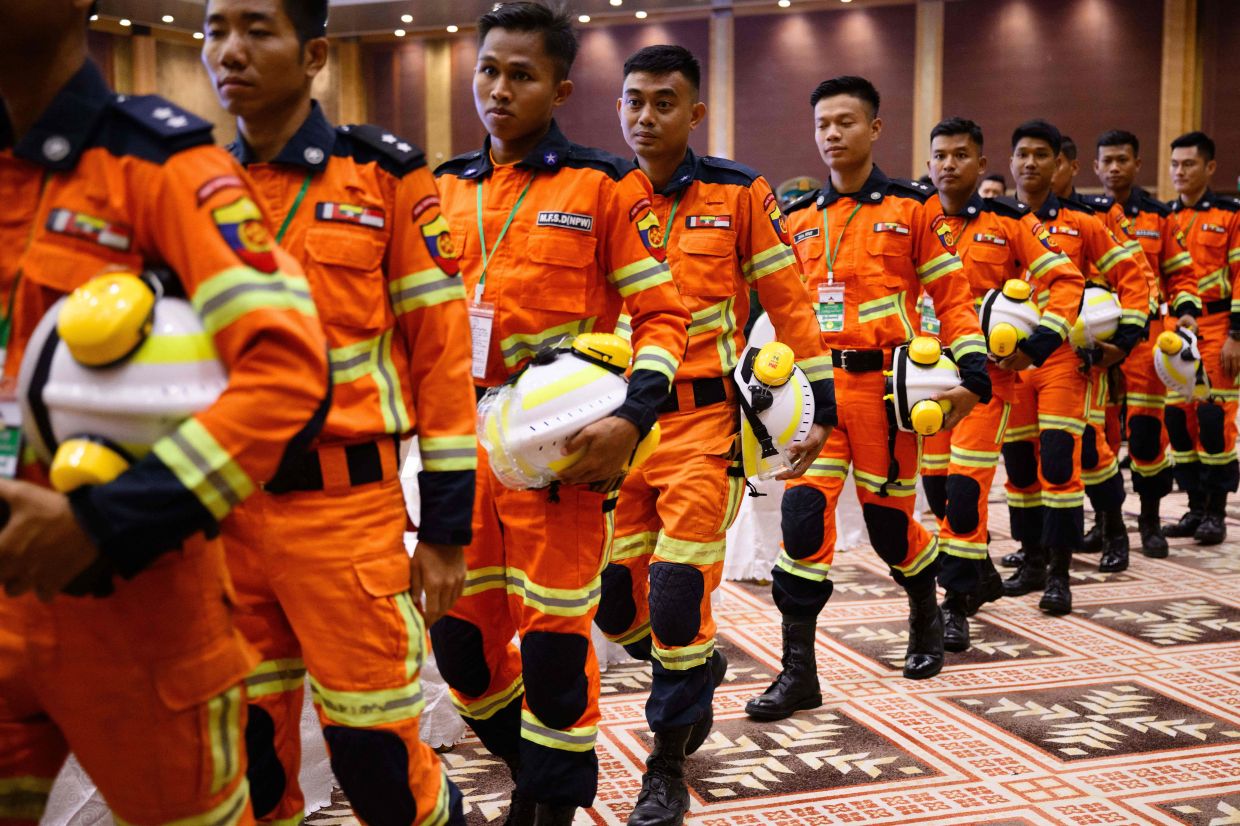 Firefighters leave after a memorial event at the Myanmar International Convention Centre (MICC) in Naypyidaw on Saturday, March 28, 2026, to mark the first anniversary since a 7.7-magnitude tremor struck, killing more than 3,800 people in Myanmar -- and around 90 more in neighbouring Thailand. (Photo by ANTHONY WALLACE / AFP)