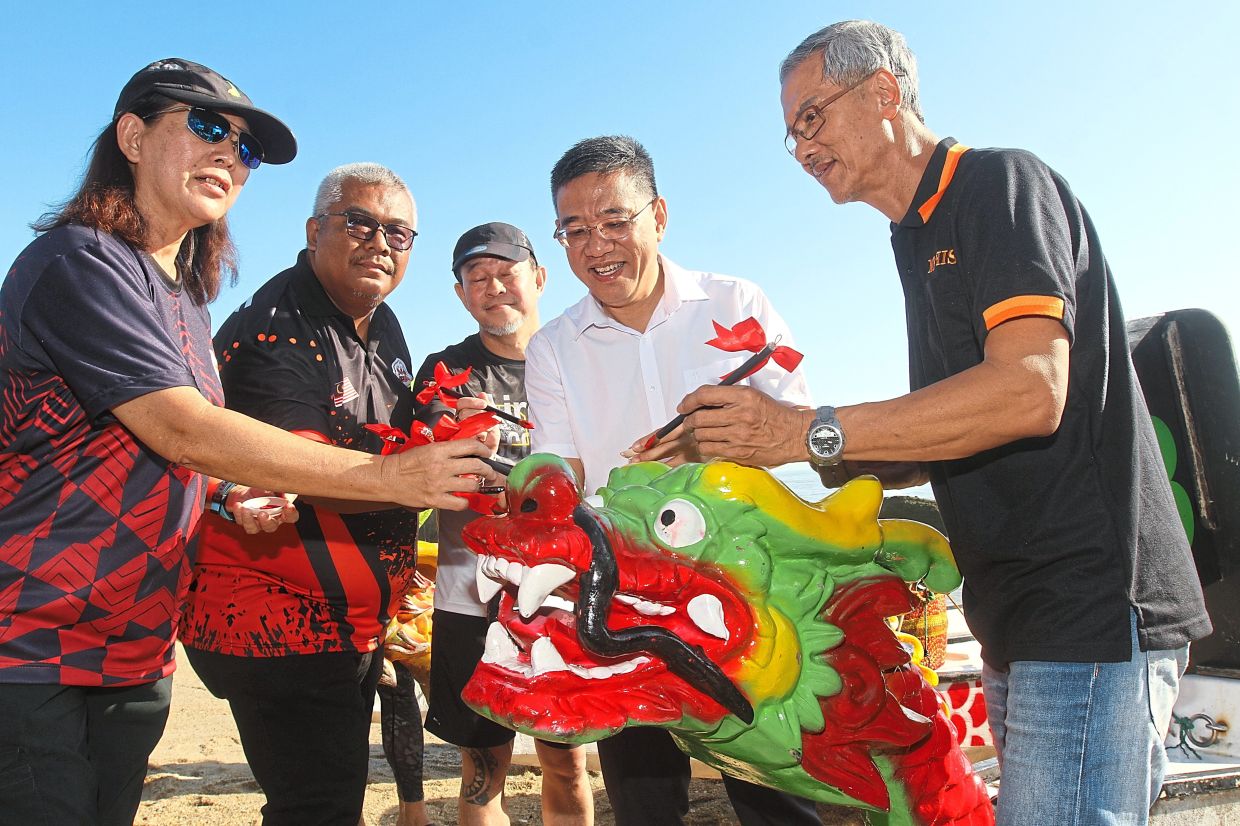 Wong (in white) dotting the eye of a ‘dragon’ during the opening ceremony of the Penang Mini Dragon Boat Race 2026 in Tanjung Bungah. With him (from left) are Tan, Raja Amran Shah and sponsors James Yee and Thor Beng Boon.