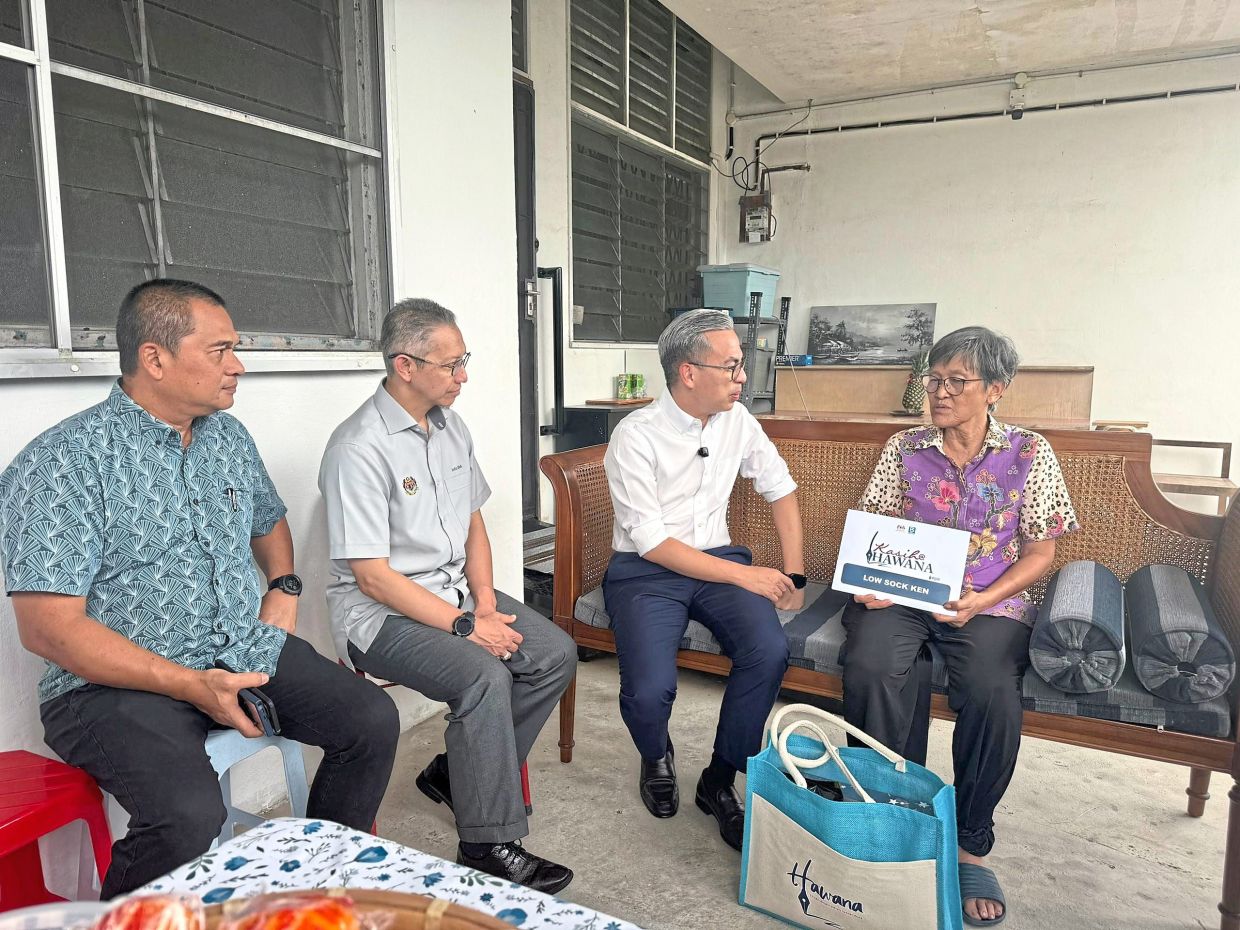 Fahmi (second from right) talking to Low at her home in Taman Ungku Tun Aminah. Looking on is Communications Ministry secretary-general Datuk Abdul Halim Hamzah (second from left) and Mohamad Fauzi.