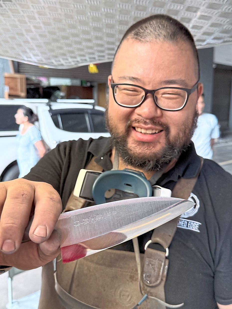Loh, showing off a blade edge he just sharpened, says quality matters when it comes to knives.
