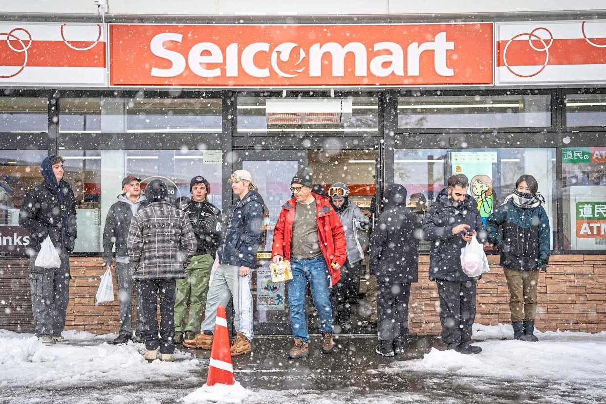 Tourists loitering in front of a convenience store in Kutchan. The influx of visitors to the area isn't really boosting local economy.