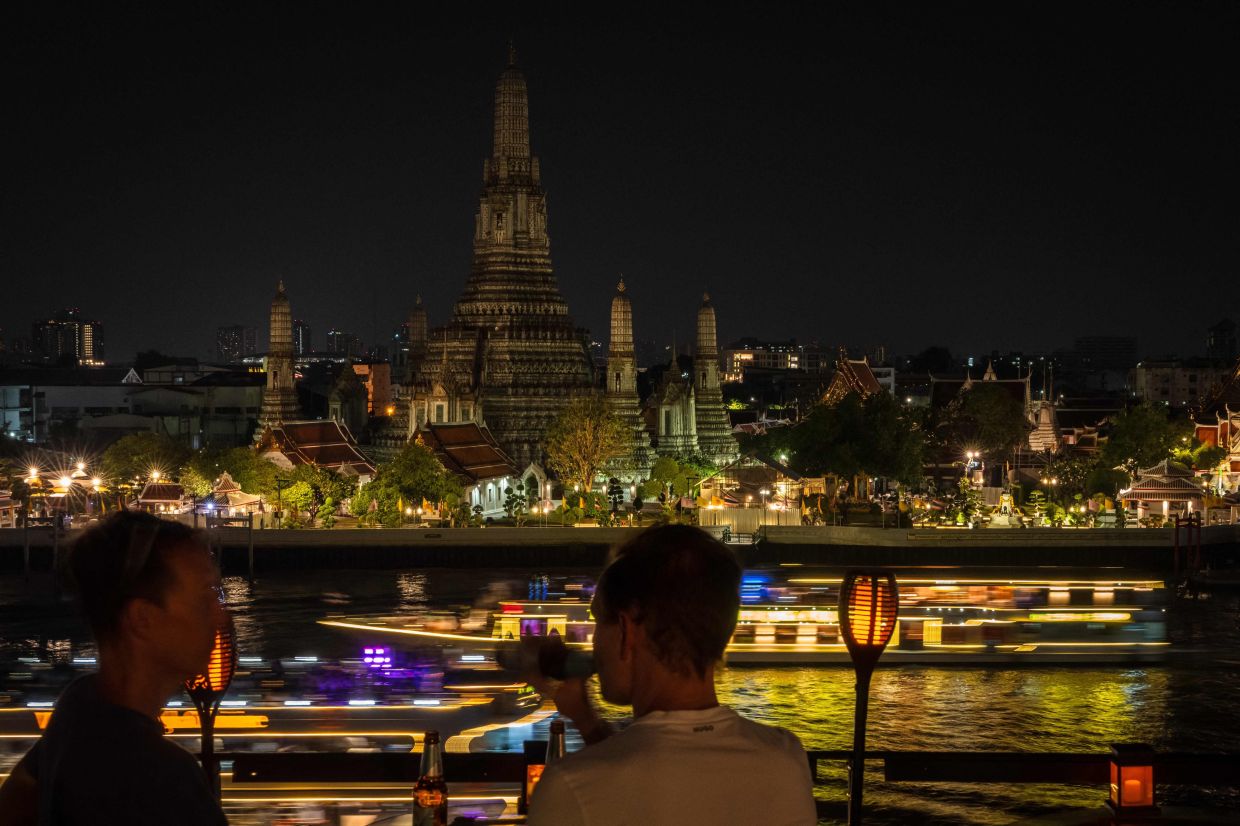The Wat Arun Buddhist temple is pictured after its lights are turned off to mark Earth Hour in Bangkok. -- Photo by Chanakarn LAOSARAKHAM / AFP