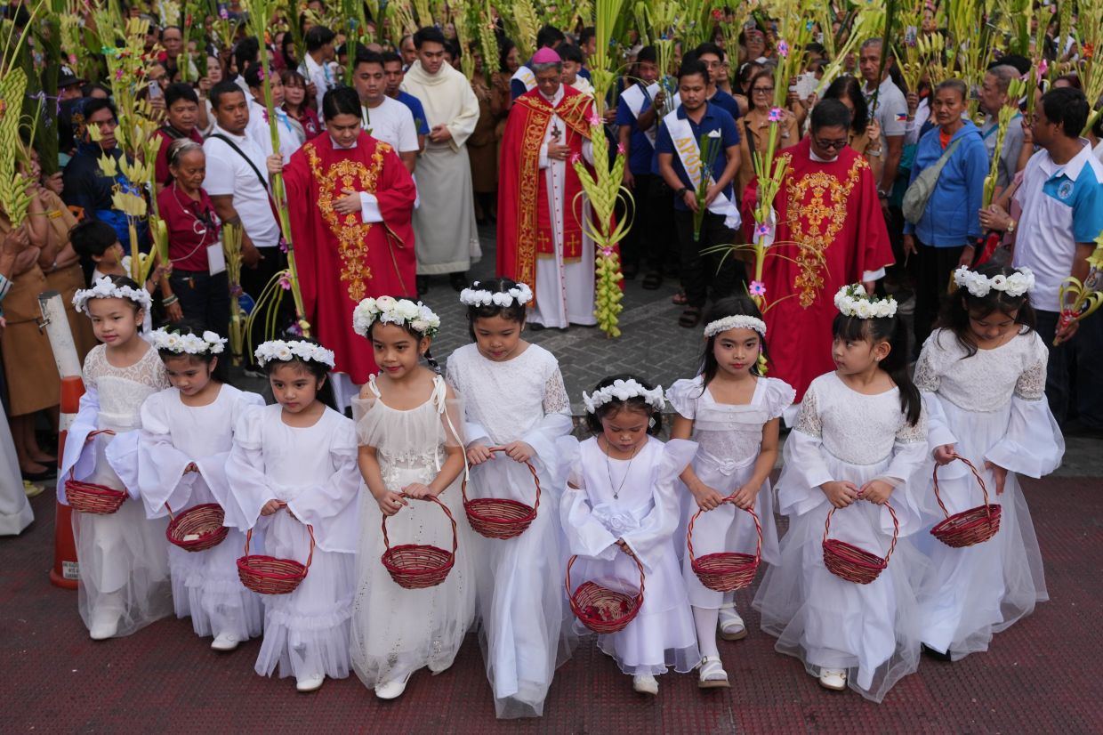 Girls join a procession during rites outside the Antipolo Cathedral in Antipolo city, Rizal province, Philippines, as they observe Palm Sunday, March 29, 2026. -- AP Photo/Aaron Favila