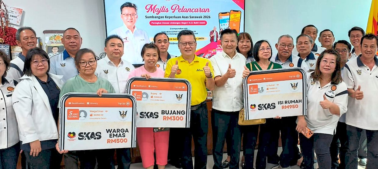 Chieng (in yellow shirt) with recipients of SKAS 2026 alongside community leaders at the handover ceremony for Bukit Assek state constituency in Sibu.