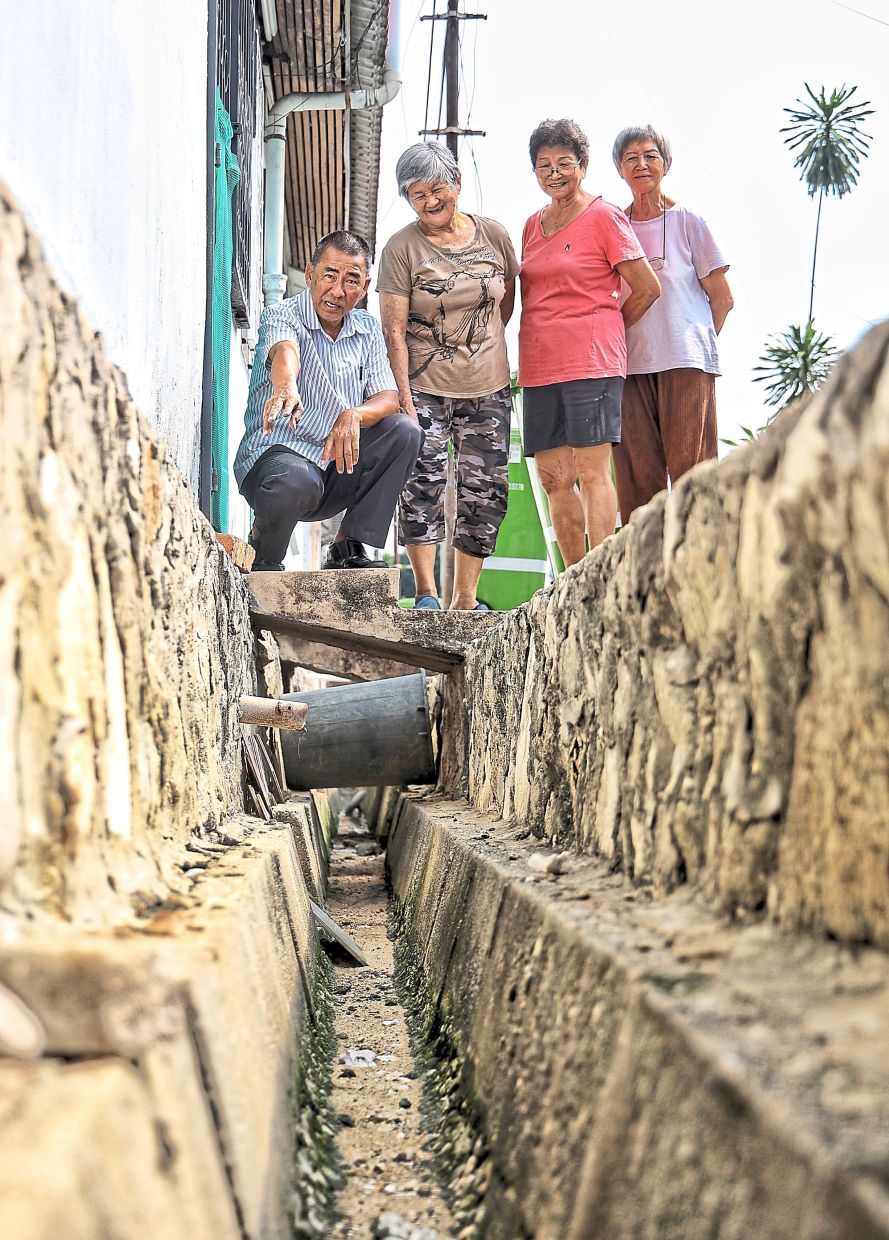 Yee (left), accompanied by residents, showing an ageing drain along Jalan Lang Perut Putih 6 in Kepong. — Photos: MUHAMAD SHAHRIL ROSLI/The Star