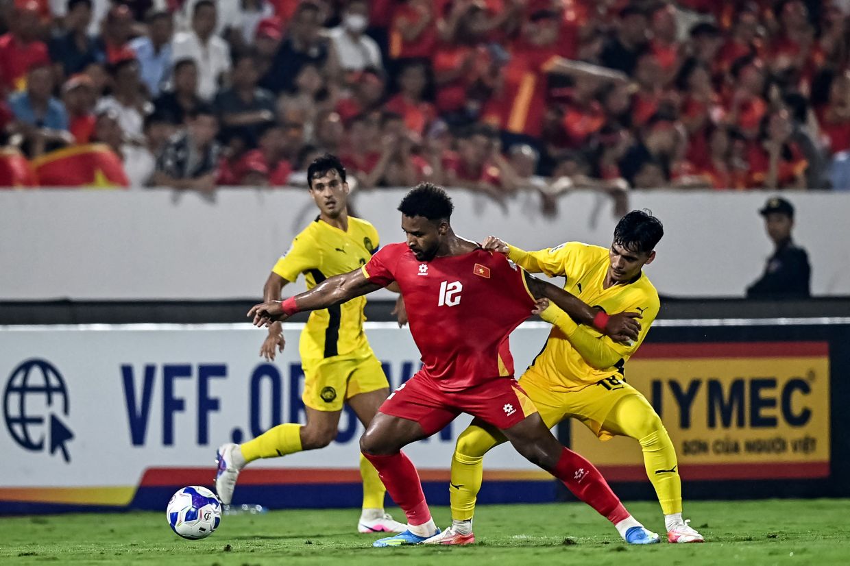 Vietnam's Nguyen Xuan Son (centre) fights for the ball with Malaysian players during the AFC Asian Cup qualifier Group F football match between Vietnam and Malaysia at the Thien Truong Stadium in Ninh Bình province on Tuesday, March 31, 2026. -- Photo by Nhac NGUYEN / AFP