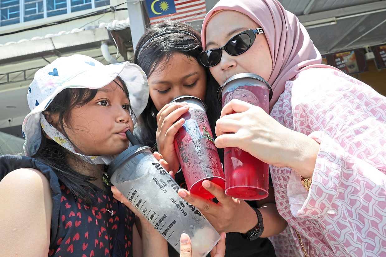 A family cooling down with Penang’s famous ‘ais tingkap’ from Lebuh Tamil in George Town.