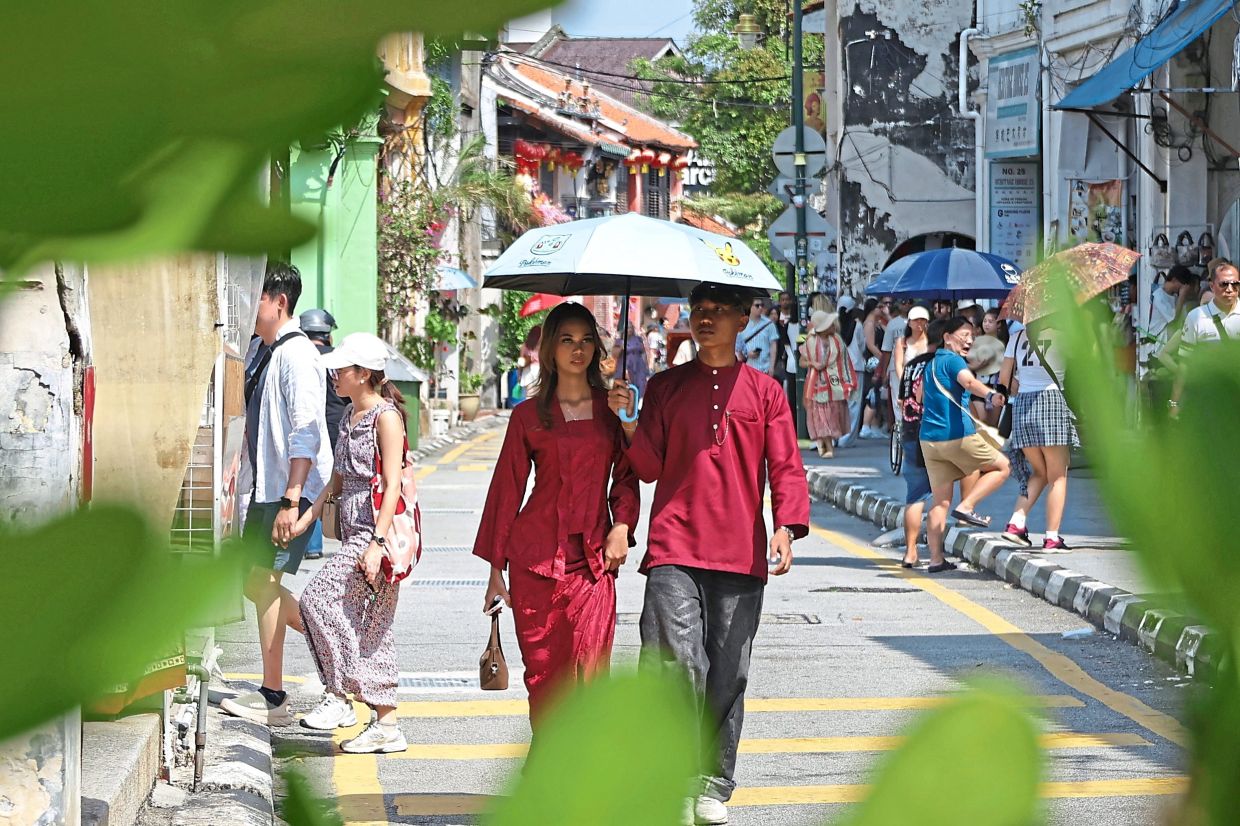 Locals and tourists in Armenian Street armed with brollies for protection from the sun.