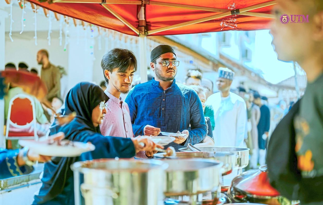 International students selecting food from the buffet at the Raya open house held at the UTM vice-chancellor’s official residence.