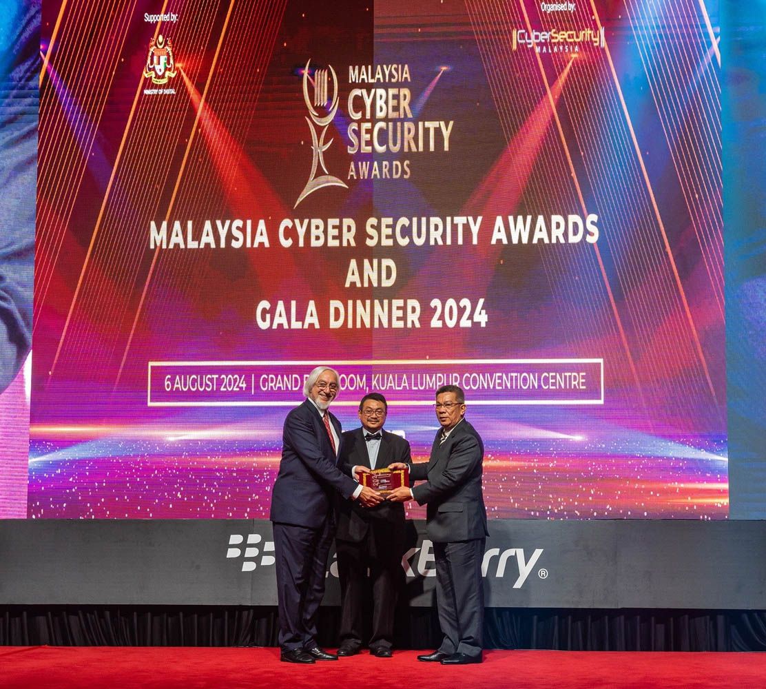 Defence Ministry cyber and electromagnetic defence division director general Rear Admiral Datuk Mohd Fadzli Kamal Mohd Mohaldin (right) presenting Parmjit (left) with the award at the 2024 Malaysia Cyber Security Awards, witnessed by Amirudin (centre).