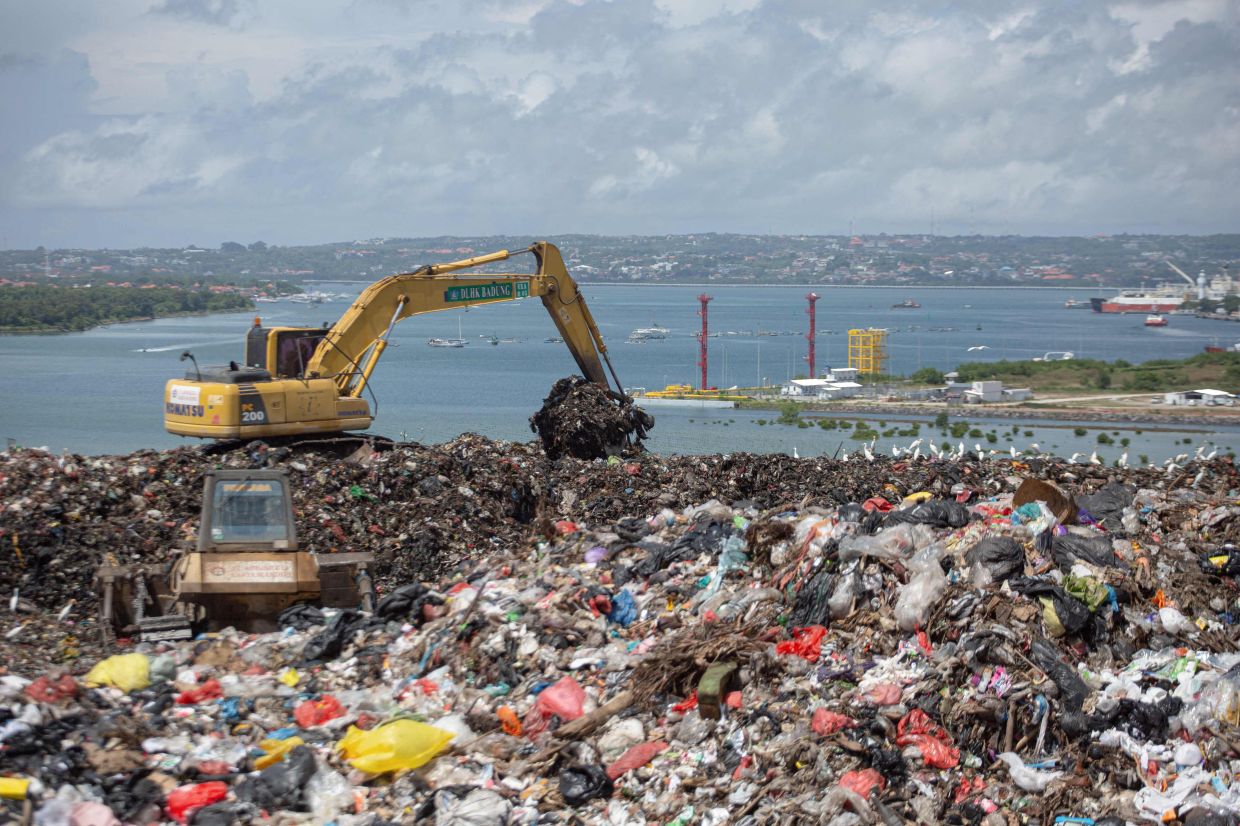 An excavator movings trash at the Suwung landfill in Denpasar on April 2, 2026, as authorities ban organic waste, which accounts for around 65 per cent of Bali's total waste and poses environmental risks, ahead of the sit's planned permanent closure in August. - AFP