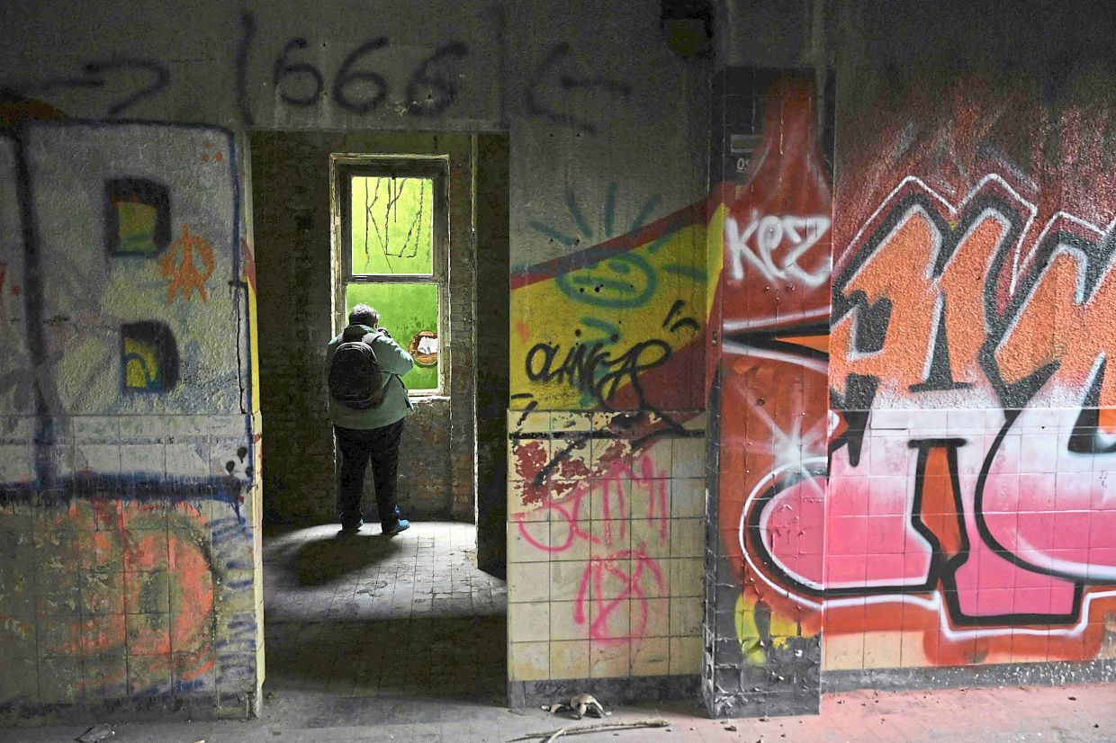 An urbexed taking pictures photographs in an abandoned public swimming pool.