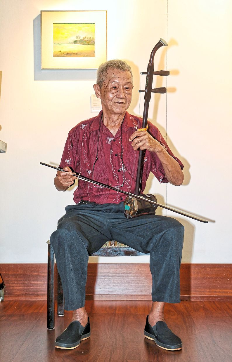 Chia entertaining visitors to his exhibition, Sound of Silent, with his erhu. — MUHAMAD SHAHRIL ROSLI/The Star